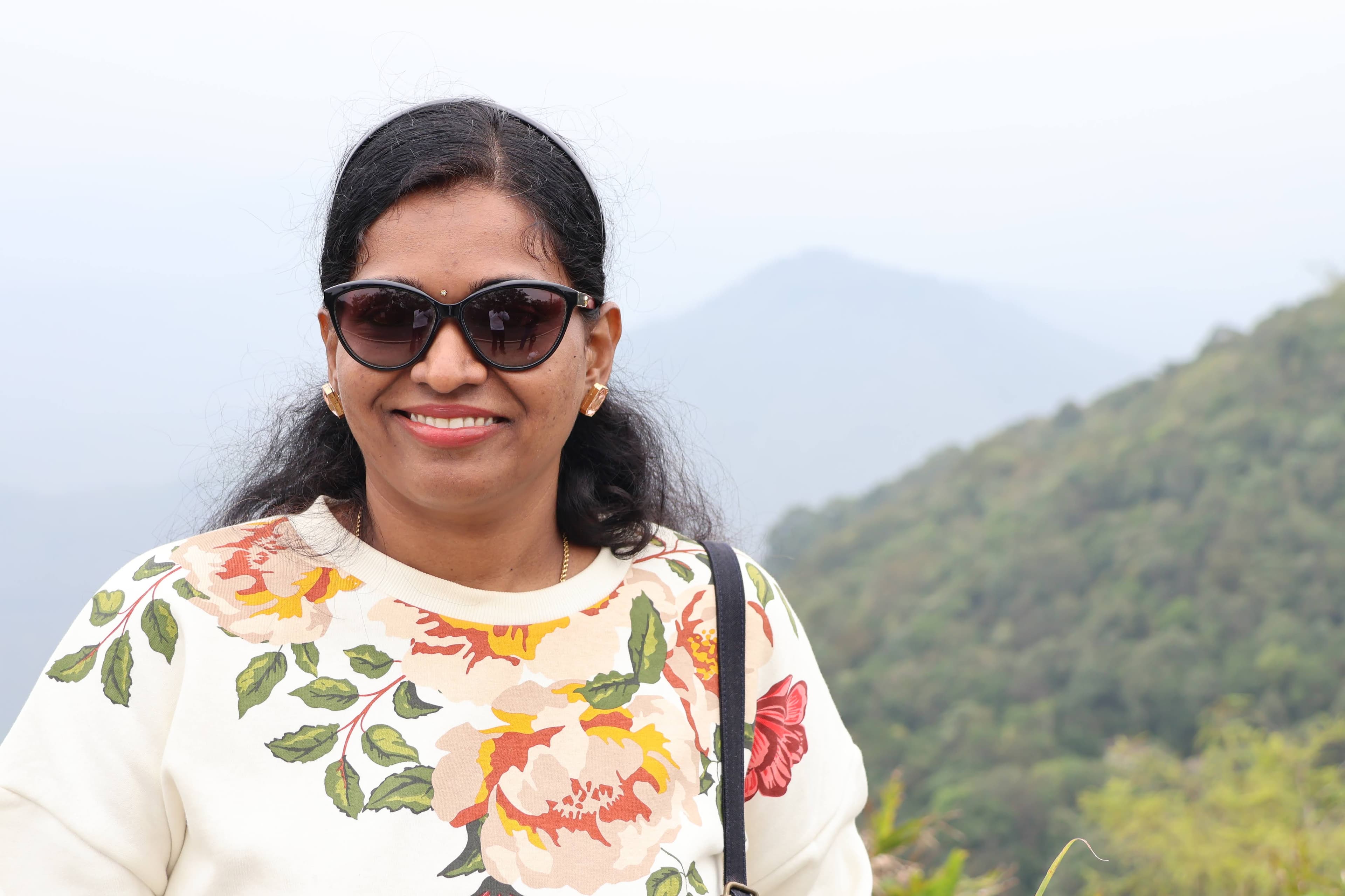 Saranya smiling against a mountain backdrop