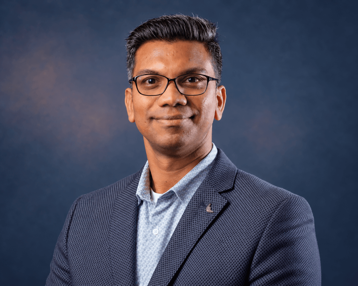Portrait of Ram against a slate-blue background